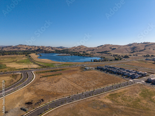 Developing residential area showcasing new homes, empty land plots, and roads near Lagoon Valley Park, symbolizing urban expansion and real estate growth in California