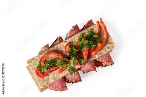 фотографія Top-down view of a gourmet crispbread sandwich with salami, red pepper, and herb