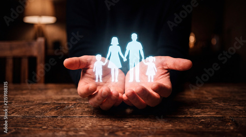 Hands holding a glowing digital hologram of a family silhouette in a dark setting, digital life insurance, family protection, safe future planning, modern healthcare technology.