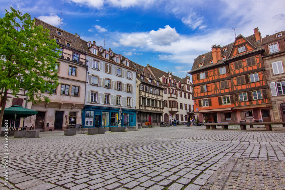 Obraz premium Historic Saint Stephen's Square in Strasbourg, France, surrounded by traditional half-timbered houses with colorful facades, wooden shutters and steep tiled roofs.