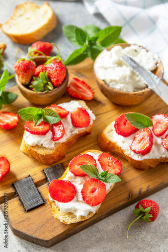 Fotografie Bruschetta with ricotta and strawberry on a stone tabletop