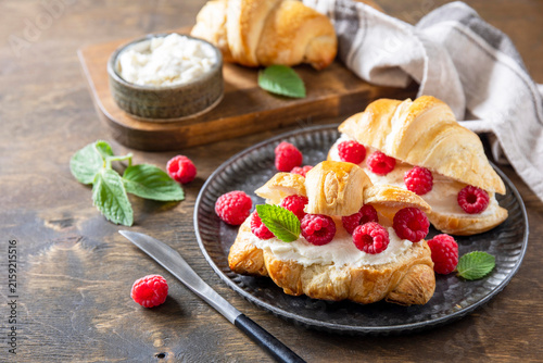 Sweet breakfast croissant sandwich with raspberries and cream cheese. Homemade and healthy french croissant for breakfast. Copy space.