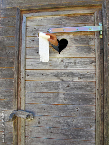 stuhlgang - defecation. hand showing toilet paper through a toilet door window. Hand zeigt Klopapier durch das Fenster einer Toilette.