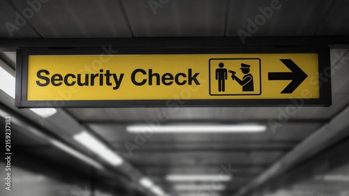Yellow Security Check directional sign at an airport terminal or public transport station.