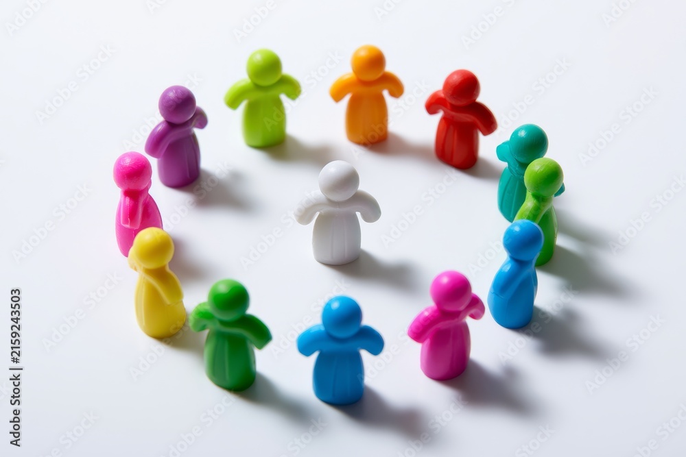 Fototapeta premium Colorful figures arranged in a circle with one figure in the center on a white surface