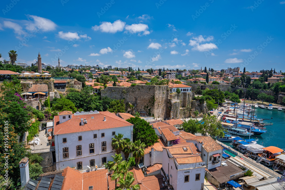 Fototapeta premium Historic Kaleici rooftops and marina beneath summer clouds in Antalya, Turkey.