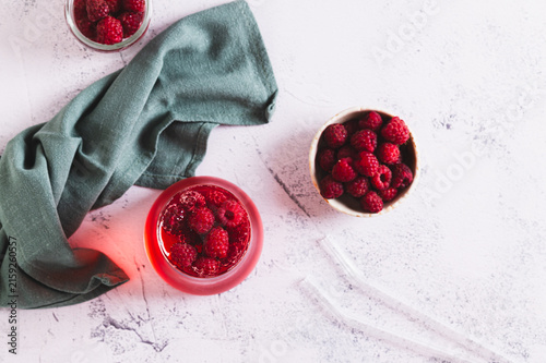Quadro su tela Cold raspberry compote in a glass and berries in a bowl on the table top view