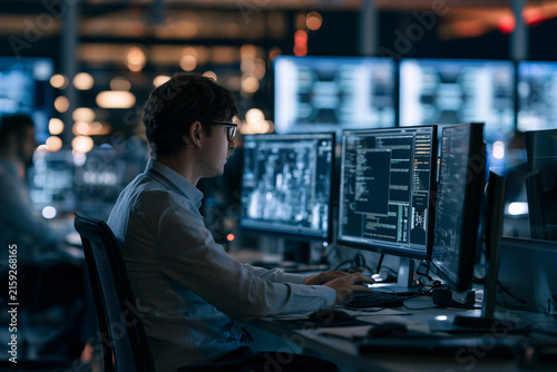 Technology professional monitoring AI powered cybersecurity risk analysis platform in enterprise office