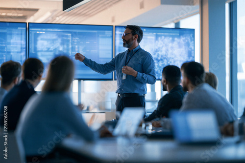 Business consultant presenting AI solutions to corporate team in modern technology meeting room