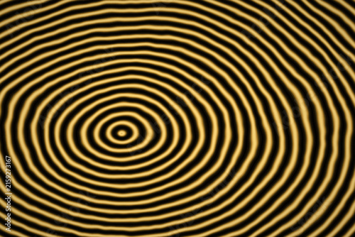 Abstract circular ripples pattern with golden yellow and black hues for dynamic graphic backgrounds