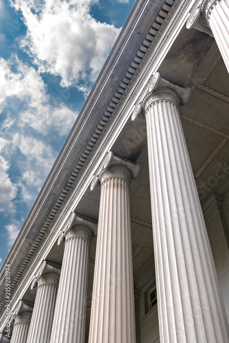 Quadro su tela Vertical low angle view follows the Treasury Building Ionic colonnade toward clouds