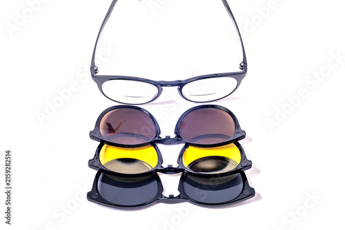 Fotografía Eyeglasses align above three colored polarized clip on lenses in a front view