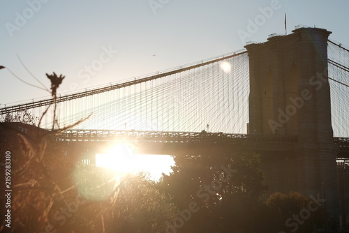Brooklyn Bridge silhouetted against the setting sun in New York City