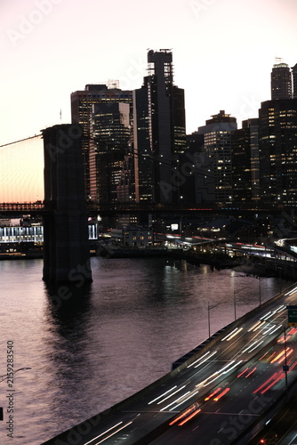 Cars blurred on a freeway with manhattan nyc skyline silhouette during evening dusk
