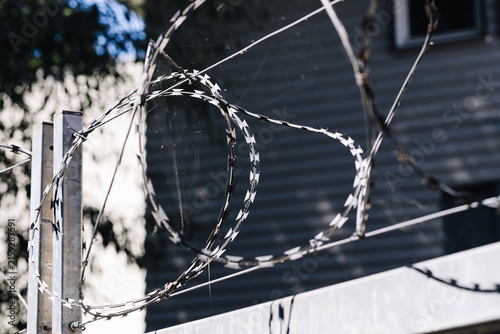 Canvas Print Razor wire stretches above a fence