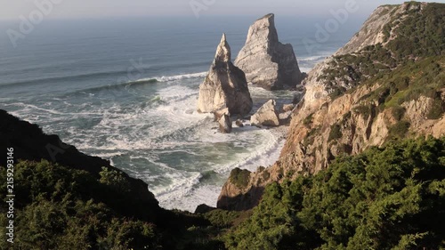 Scenic ocean waves crashing on rocky ursa beach coast in sintra, portugal