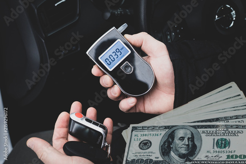 Foto a man with a breathalyzer in the car, testing for alcohol and drug intoxication