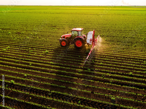 Tractor spraying soybean field with herbicide by drone