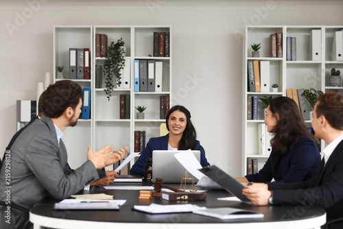Female lawyer working with colleagues at table in office