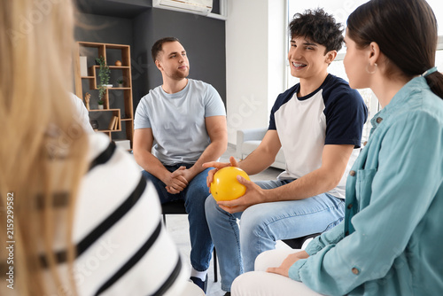 Smiling young man with ball at group therapy session