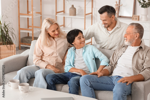 Little boy with his family sitting on sofa at home