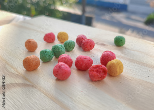 Colorful round corn snack balls on a wooden board