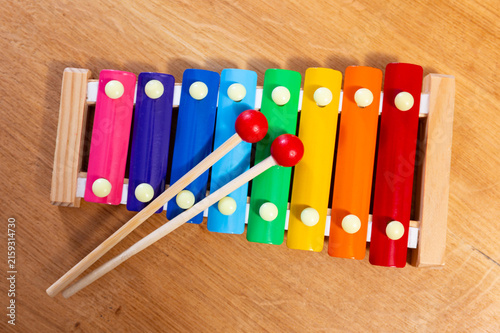 Canvastavla Children multi-colored xylophone with sticks on a wooden background