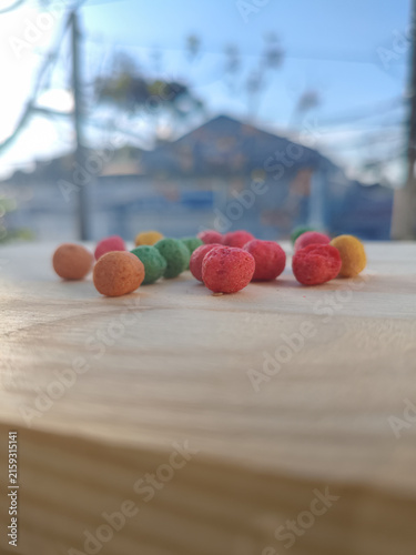Colorful round corn snack balls on a wooden board
