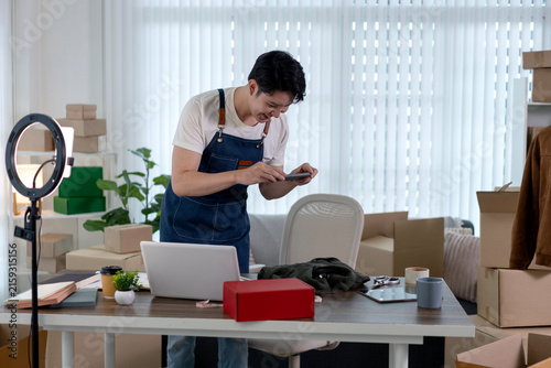 Foto Young Male Entrepreneur Photographing Product with Smartphone for Online Store a
