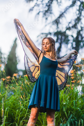 Obraz na płótnie Young woman posing as forest fairy with butterfly wings