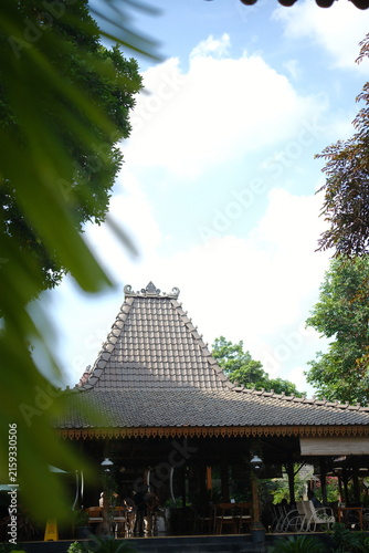 Traditional Javanese Joglo house architecture with wooden roof structure in tropical garden