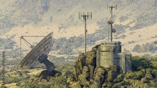Close satellite dish beside concrete bunker with rusted reflector and antenna array on rocky outcrop weathered metal and stone textures emphasize durable