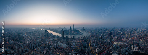 Photography A panoramic aerial shot of a dense urban city with a winding river cutting through its skyline at dawn, under a clear gradient sky