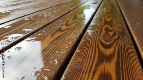 Wet wooden deck planks with water droplets reflecting the sky image photo