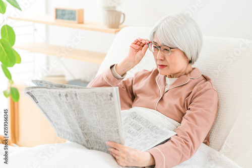 фотографія Senior citizens reading newspapers, elderly women (with presbyopia, unable to re