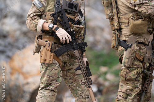 Cuadro en lienzo Military soldier is carrying rifle gun during field operation in dangerous battl