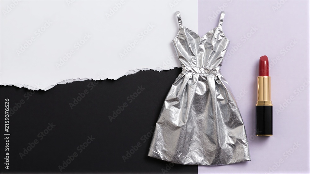 Naklejka premium Silver dress and red lipstick on torn black-white background.