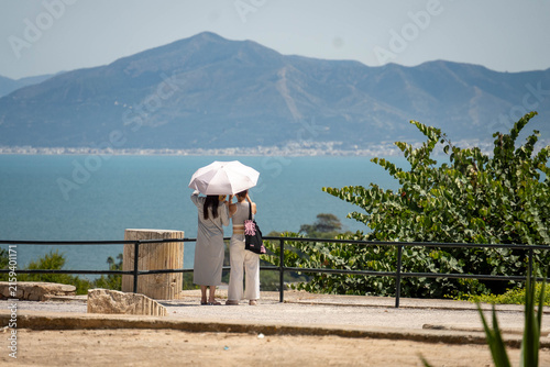 Foto Two women with a white umbrella looking out over the Lake of Tunis, in the ruins