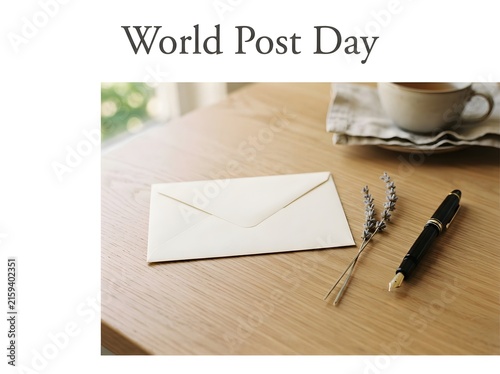 World post day concept with a white envelope and black pen on a wooden desk surface