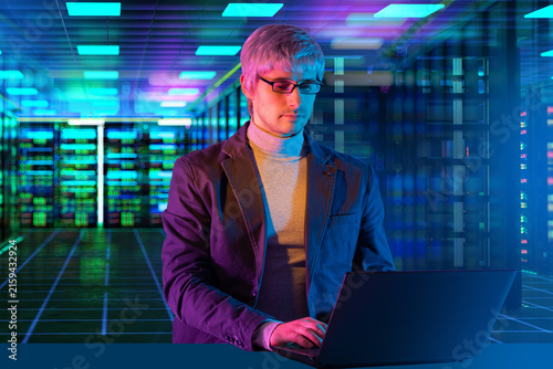 Data center operations. IT specialist manages server infrastructure using laptop during network administration, cybersecurity monitoring and cloud computing support.