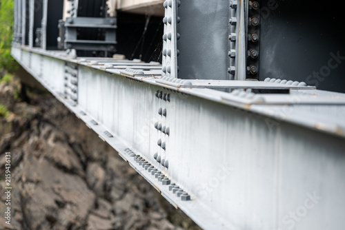 Fotografie close-up of structural steel girders and bolted riveted joints on a metal bridge framework