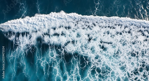 Aerial drone view of a powerful breaking ocean wave with white sea foam and turquoise deep water