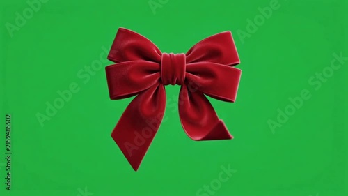 Realistic red bow on green background.