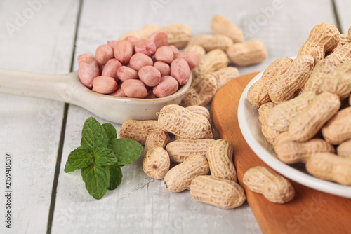 Bild auf Leinwand Fresh Peanuts in Shell and Red Skin Peanuts with Mint on Wooden Background