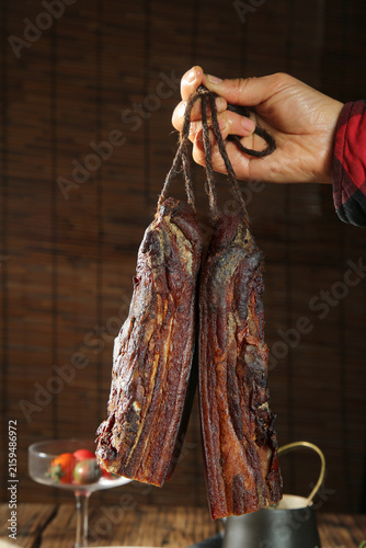 Foto Traditional Chinese Dried Cured Bacon Strips Hanging on Rope - Szechuan Preserve
