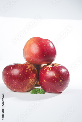 Foto Fresh Red Apples from Yunnan China with Mint Leaves on White Background