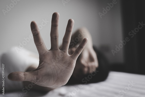 Woman using a stop hand gesture to represent protection, freedom, justice and support for victims of abuse, exploitation and human trafficking.
