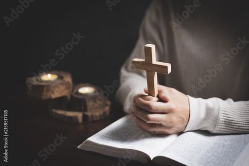 Fotografie A Christian woman praying beside a cross in a quiet room, expressing faith, hope, devotion, peace, and trust in God