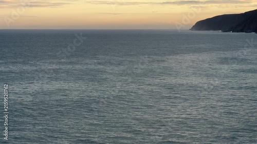 Calm ocean water texture with horizon and cliffs as a background in 60FPS 4K video footage