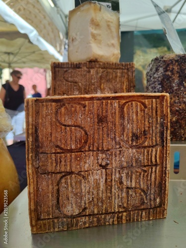 Artisanal hard cheese at form of square pieces displayed at a local farmers market cheese stall